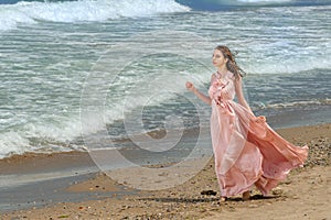 Young beautiful woman with long dress ,romantic mood on the beach with waves, Black sea side  Bulgaria