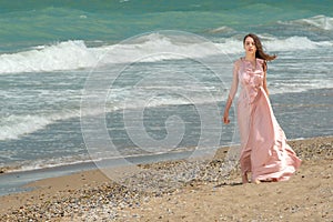 Young beautiful woman with long dress ,romantic mood on the beach with waves, Black sea side  Bulgaria