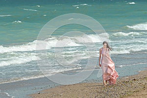 Young beautiful woman with long dress ,romantic mood on the beach with waves, Black sea side  Bulgaria