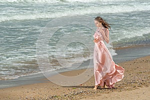 Young beautiful woman with long dress ,romantic mood on the beach with waves, Black sea side  Bulgaria