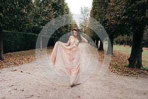 Young beautiful woman in long rose evening dress