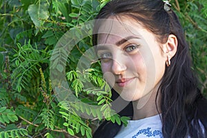 Young beautiful woman is looking at the camera and smiling. Brunette woman portrait. Happy summer time