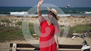 Young beautiful woman looking up at sunshine standing on Mediterranean sea beach on Cyprus. Portrait of happy smiling