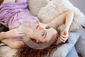 Young beautiful woman lying on bed, beautiful red hair, relaxation and relaxation concept