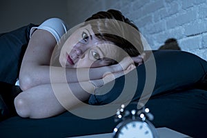 Young beautiful woman lying in bed late at night suffering from insomnia trying to sleep
