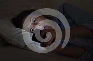 Young beautiful woman lying on home couch using mobile phone internet addiction concept