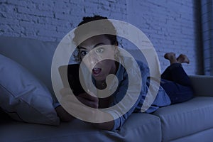 Young beautiful woman lying on home couch using mobile phone internet addiction concept