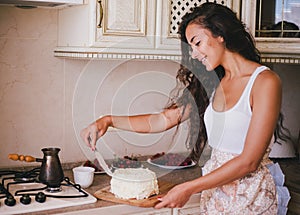 Young beautiful woman making cake at the kitchen