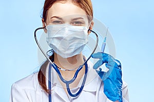 Young beautiful woman in medical clothes holds a syringe, medicine, doctor