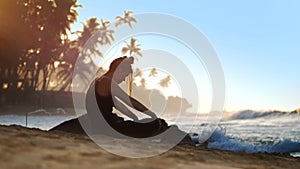 Young beautiful woman meditates against blue ocean waves