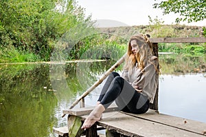 Young beautiful woman model with long blond hair sitting with different emotions laughter, sadness, sorrow, thoughtfulness on a wo photo