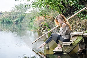 Young beautiful woman model with long blond hair sitting with different emotions laughter, sadness, sorrow, thoughtfulness on a wo photo