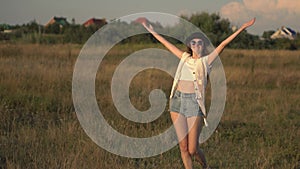 Young beautiful woman model walking on the meadow and enjoying the nature