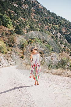 Young beautiful woman in a modern dress with mehendi posing among mountains