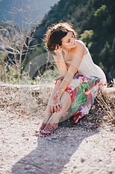 Young beautiful woman in a modern dress with mehendi posing among mountains