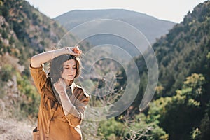 Young beautiful woman in a modern dress with mehendi posing among mountains