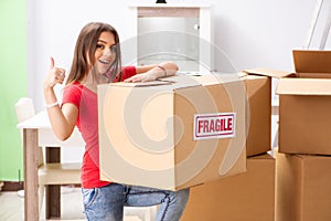 The young beautiful woman moving to new flat