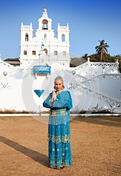 Young beautiful woman in national Indian clothes near the Catholic temple, Goa