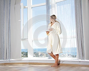 Young beautiful woman near big window