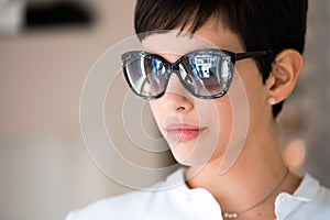 Young beautiful woman at optician with glasses buying sunglasses