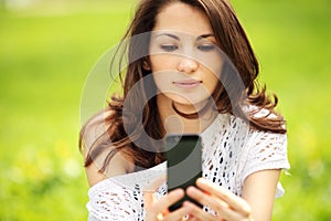 Young beautiful woman photographing in summer park