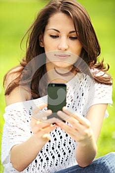 Young beautiful woman photographing in summer park