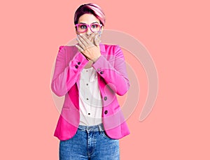 Young beautiful woman with pink hair wearing business jacket and glasses shocked covering mouth with hands for mistake