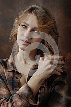 Young beautiful woman in plaid shirt with coffee mug . photo