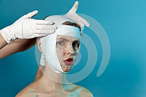 Young beautiful woman. Plastic surgery or face lifting for young woman. Doctor's hands wearing gloves and head of