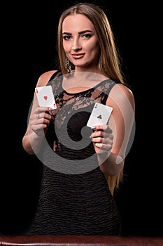 Young beautiful woman playing in casino. Girl holding the winning combination of poker cards. Two aces