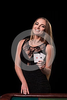 Young beautiful woman playing in casino. Girl holding the winning combination of poker cards. Two aces