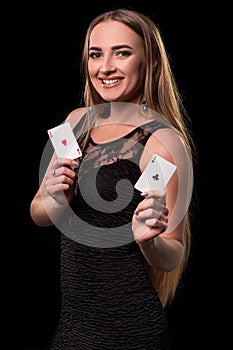 Young beautiful woman playing in casino. Girl holding the winning combination of poker cards. Two aces
