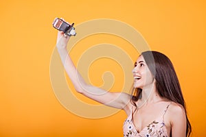 Young beautiful woman playing with toy plane in studio over yellow background