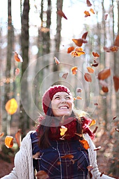 Young beautiful woman plays with beech leaves in one of the most amazing beech forest in Europe, La Fageda d'en Jorda.