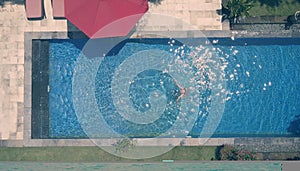 The young beautiful woman in the pool, flat lay, dron view, retro effect photo