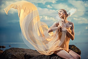 Young beautiful woman posing on the beach at sunset