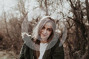 Young and beautiful woman posing at camer in park.