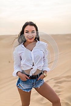Young beautiful woman posing on desert landscape