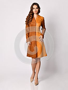 Young beautiful woman posing in new brown suede winter fashion dress