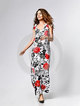 Young beautiful woman posing in new red flower pattern fashion dress on white background. Fashion spring summer photo