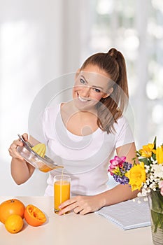 Joven mujer hermosa fundición naranja jugo vaso 