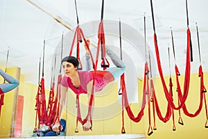 Young beautiful woman practicing yoga Fly with a hammock in the bright studio. The concept of mental and physical health