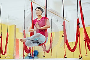 Young beautiful woman practicing yoga Fly with a hammock in the bright studio. The concept of mental and physical health