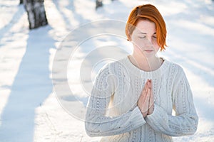 Young beautiful woman praying in forest