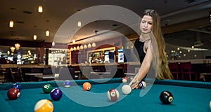 Young and beautiful woman in pub playing billiard