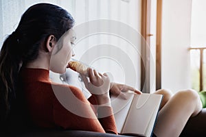 Young beautiful woman read a book with breakfast for relaxing holiday