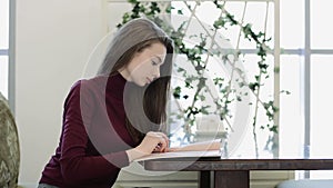 Young, beautiful woman reading menu in cafe