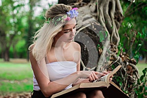 Young beautiful woman reading in the park