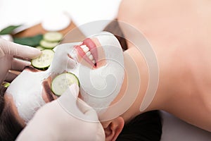 Young beautiful woman receiving clay facial mask in spa beauty salon. Skin care, Beauty treatments.