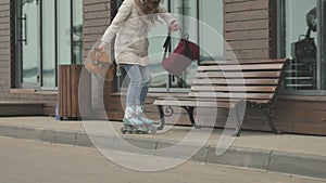 Young beautiful woman in a red hat, wearing sporty warm clothes and rollers, riding on the road on the coast